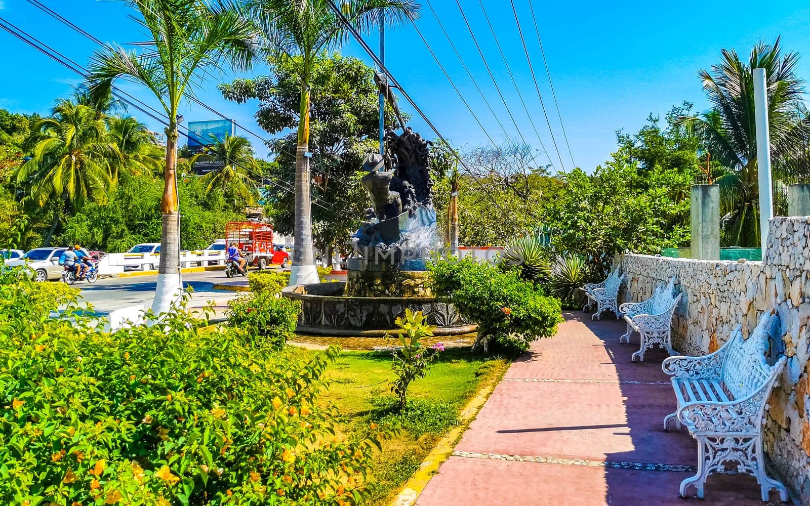 White metal park bench at the roadside Puerto Escondido Mexico. by Arkadij