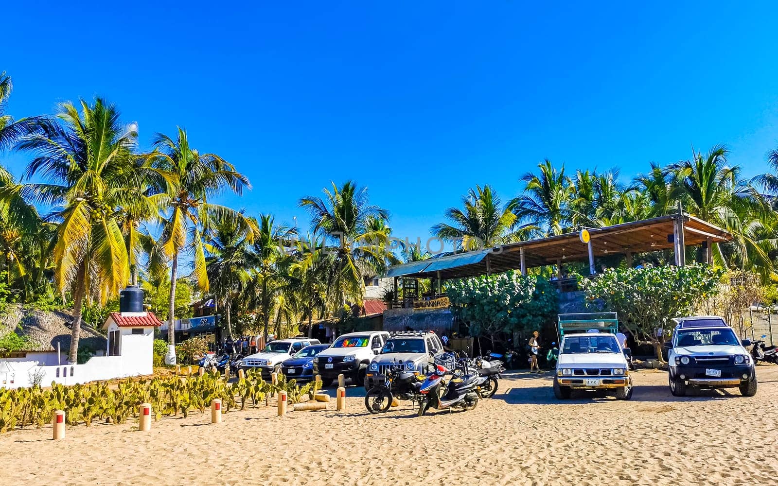 Typical beautiful colorful tourist street sidewalk city Puerto Escondido Mexico. by Arkadij