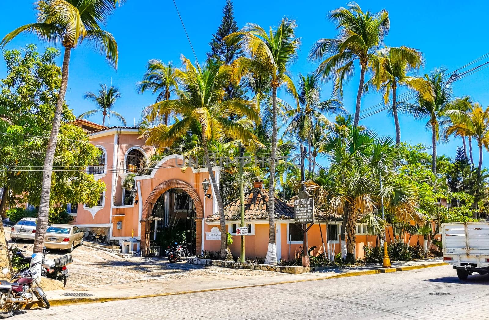 Typical beautiful colorful tourist street sidewalk city Puerto Escondido Mexico. by Arkadij