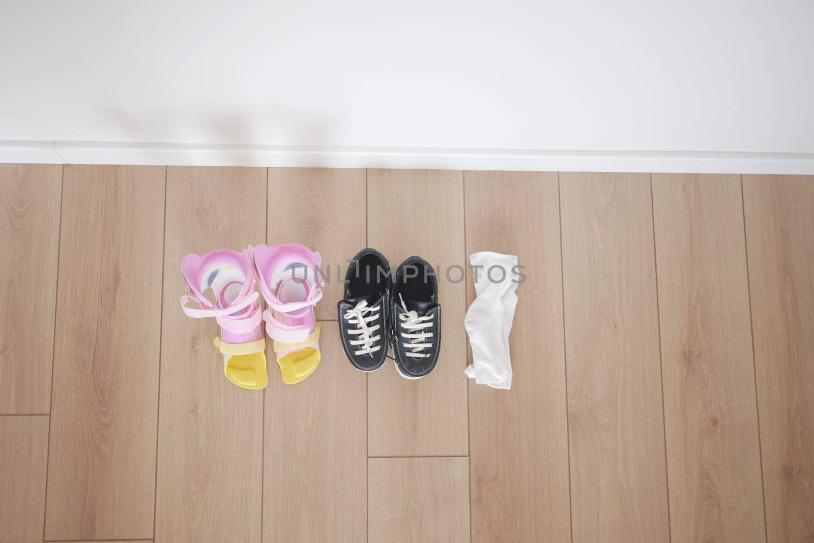 child legs orthosis and shoes on a wooden floor ,