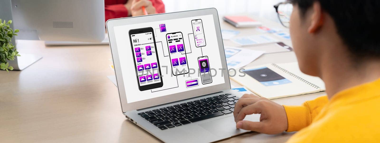 Panorama banner of startup UX developer or company employee design user interface or UI prototype for mobile application or website software with software display on laptop monitor in office. Synergic