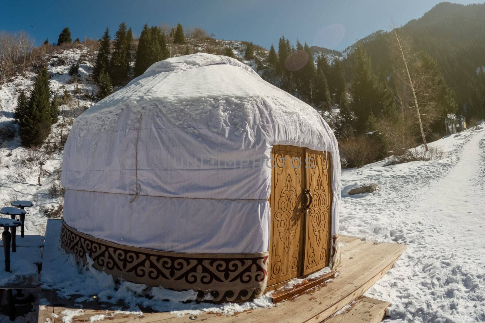 Traditional Kazakh yurt with a wooden door in the central asian mountains.