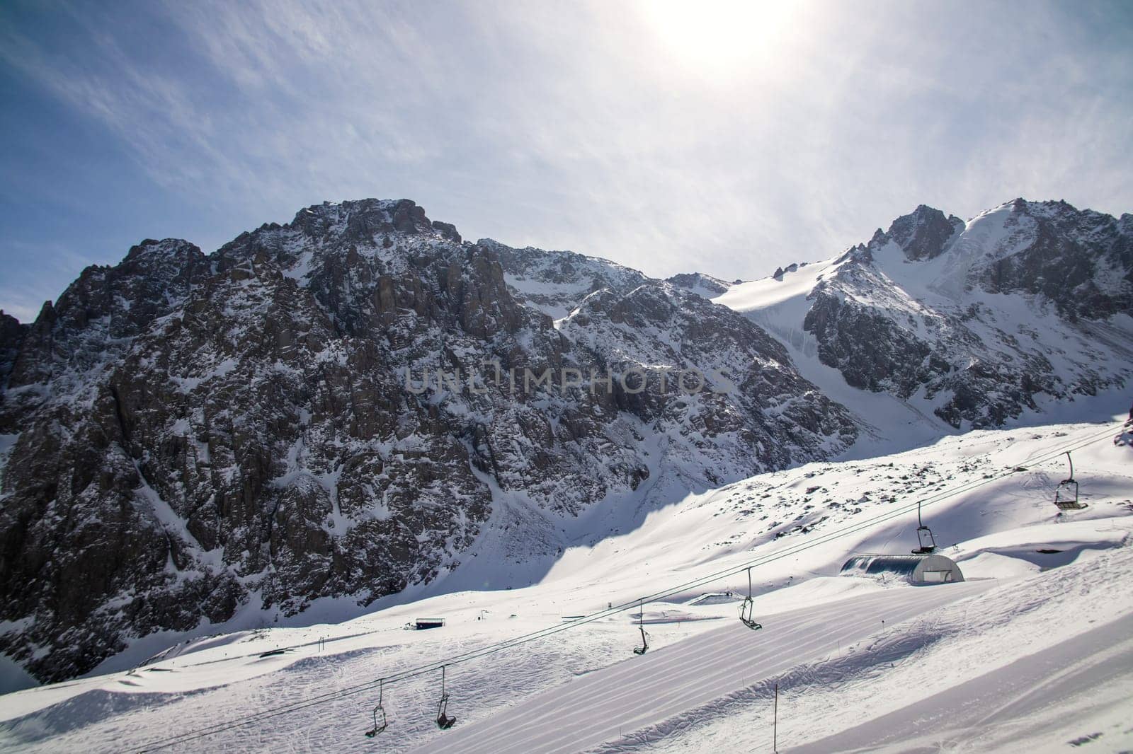 Ski lift chairs on bright winter day in high altitude mountain, copy space.