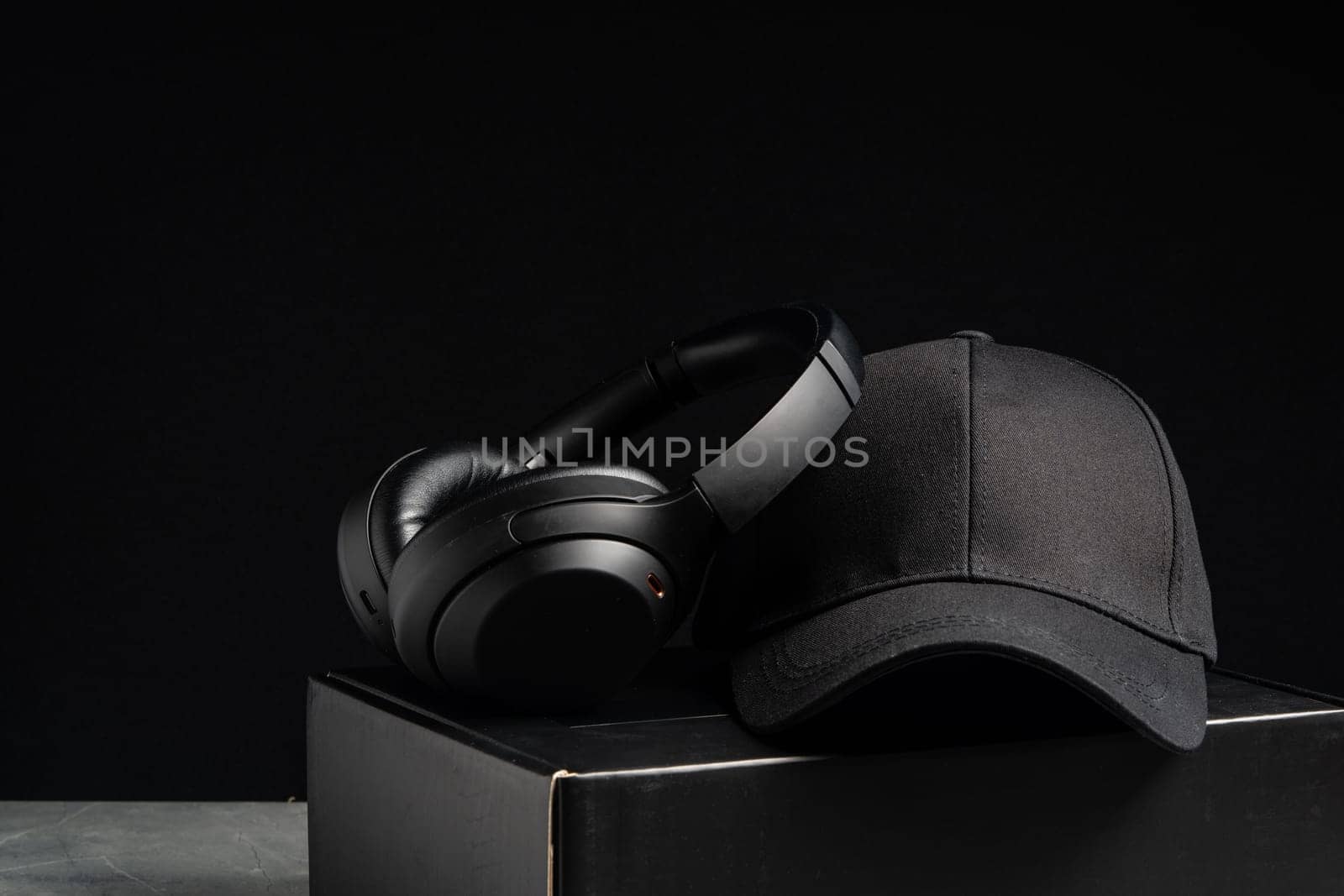 Baseball cap with black headphones on dark background studio shot