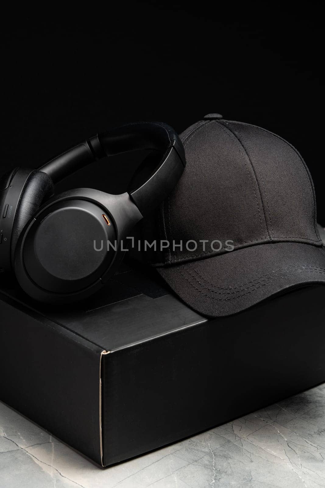 Baseball cap with black headphones on dark background studio shot