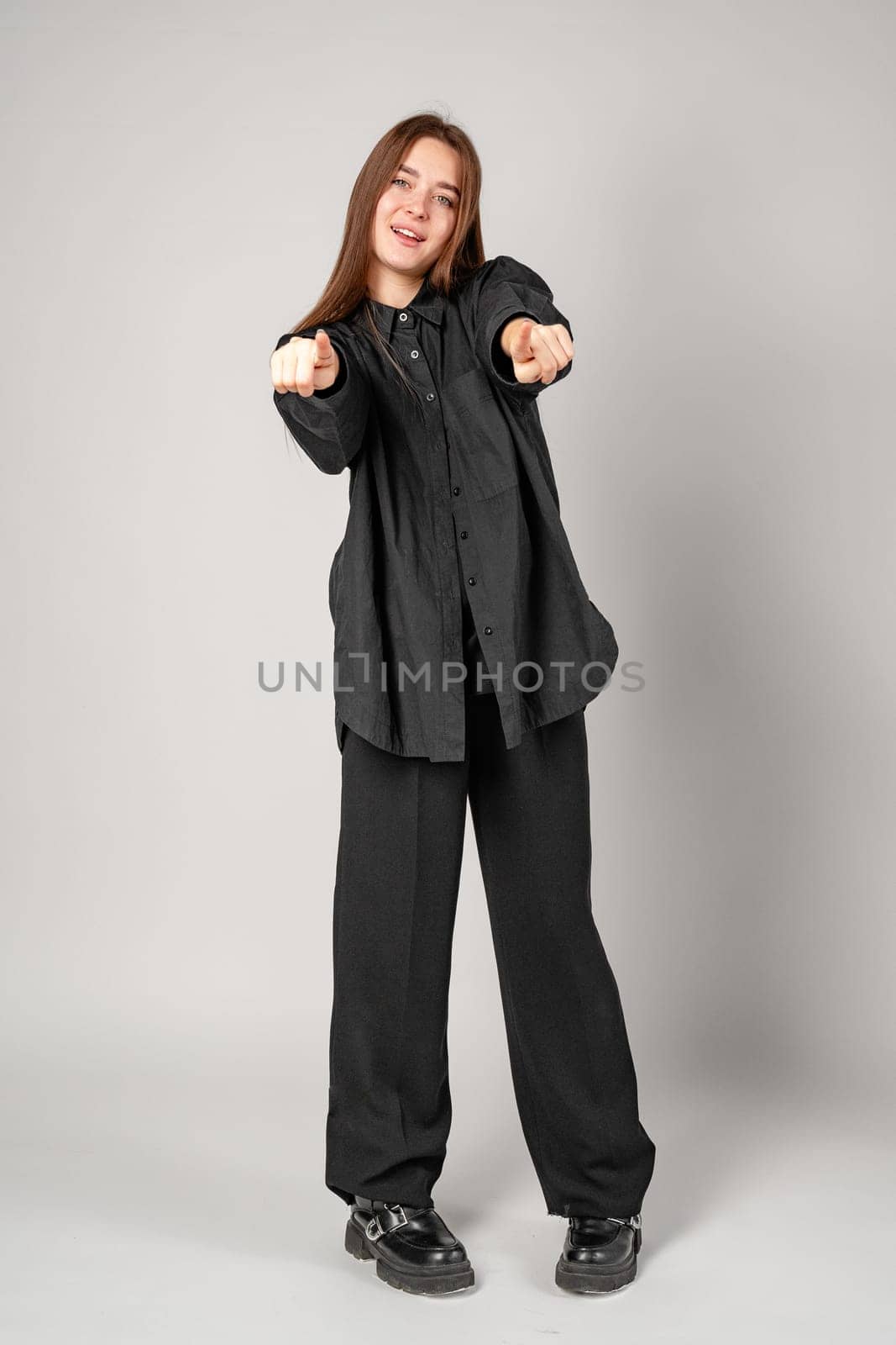 Young Woman Gesturing With Hands In Frame Against Plain Background close up