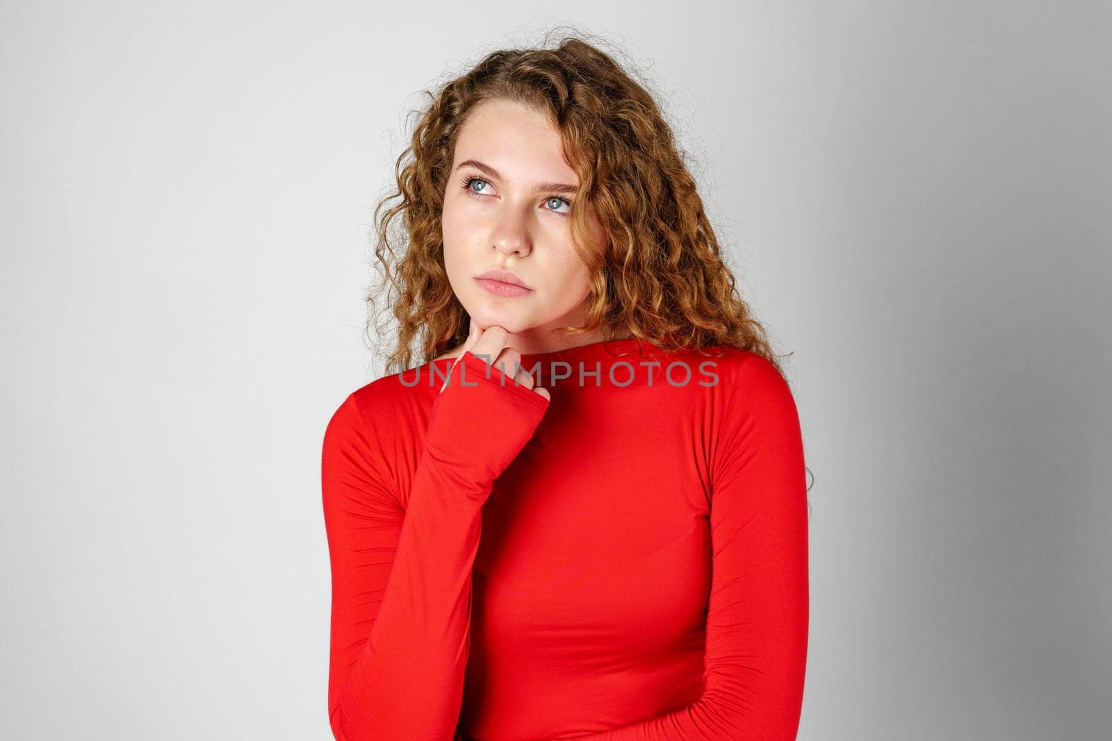 Thoughtful Young Woman Against Grey Background in Studio close up