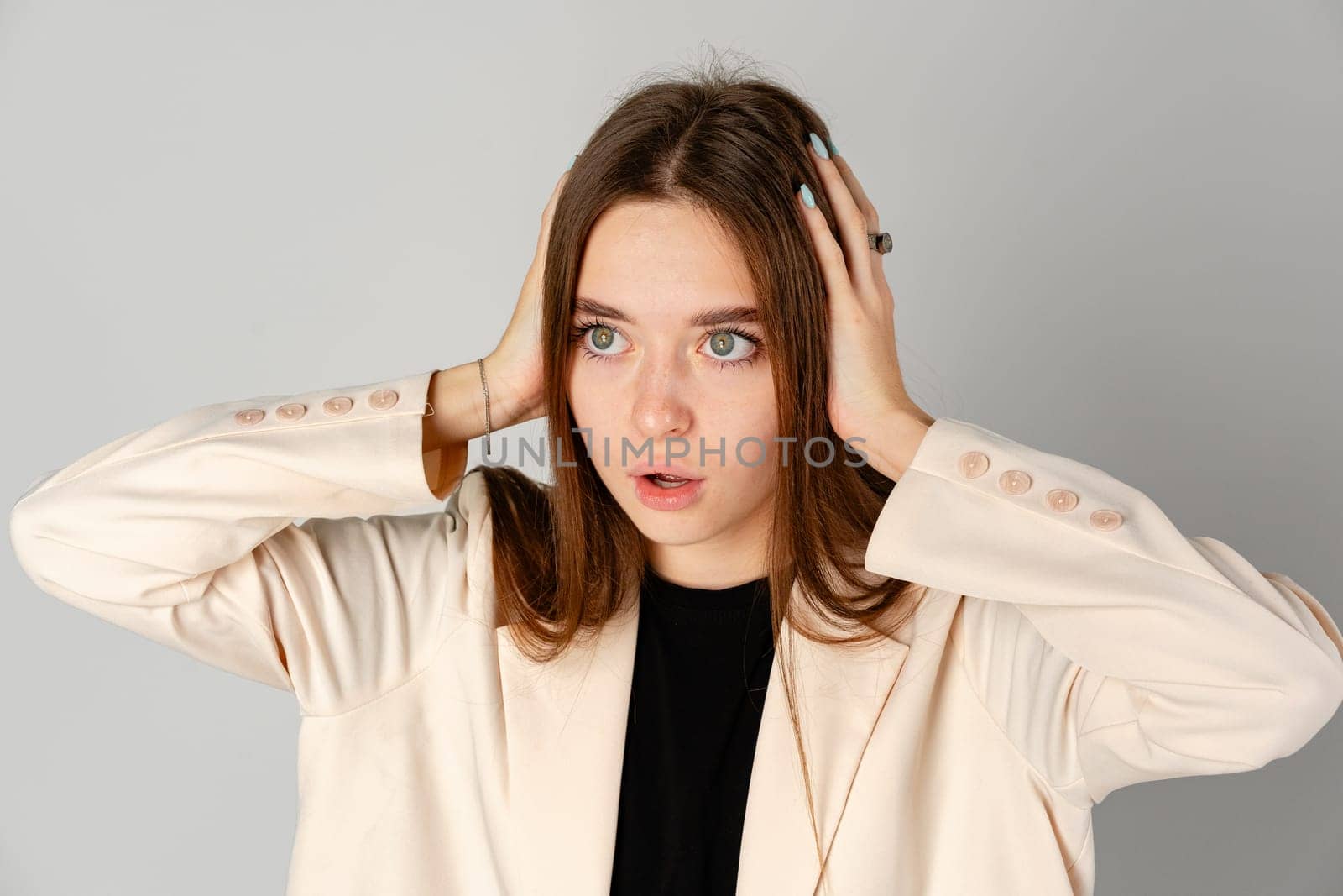 Young Woman Showing Surprise Expression on Gray Background close up