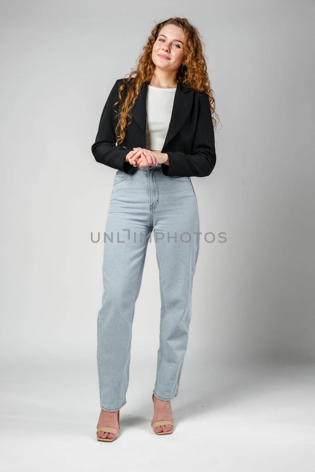 Young Woman With Curly Hair Portrait against gray background in studio