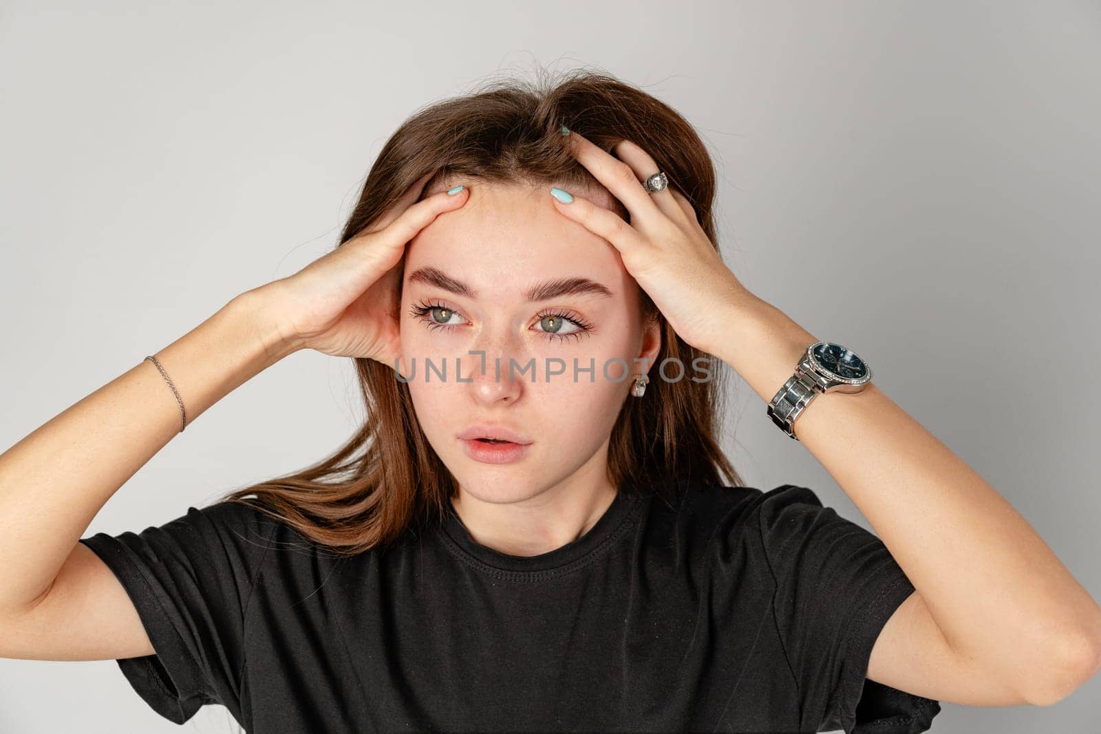 Young Woman Holding Head in Hands because of headache close up