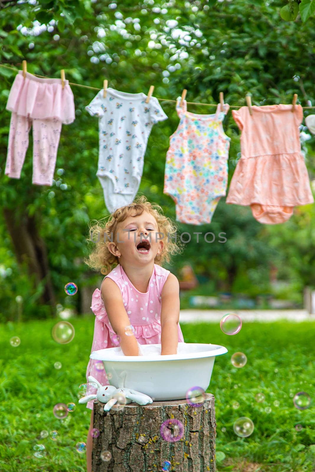 The child washes clothes and toys. Selective focus. Kid.