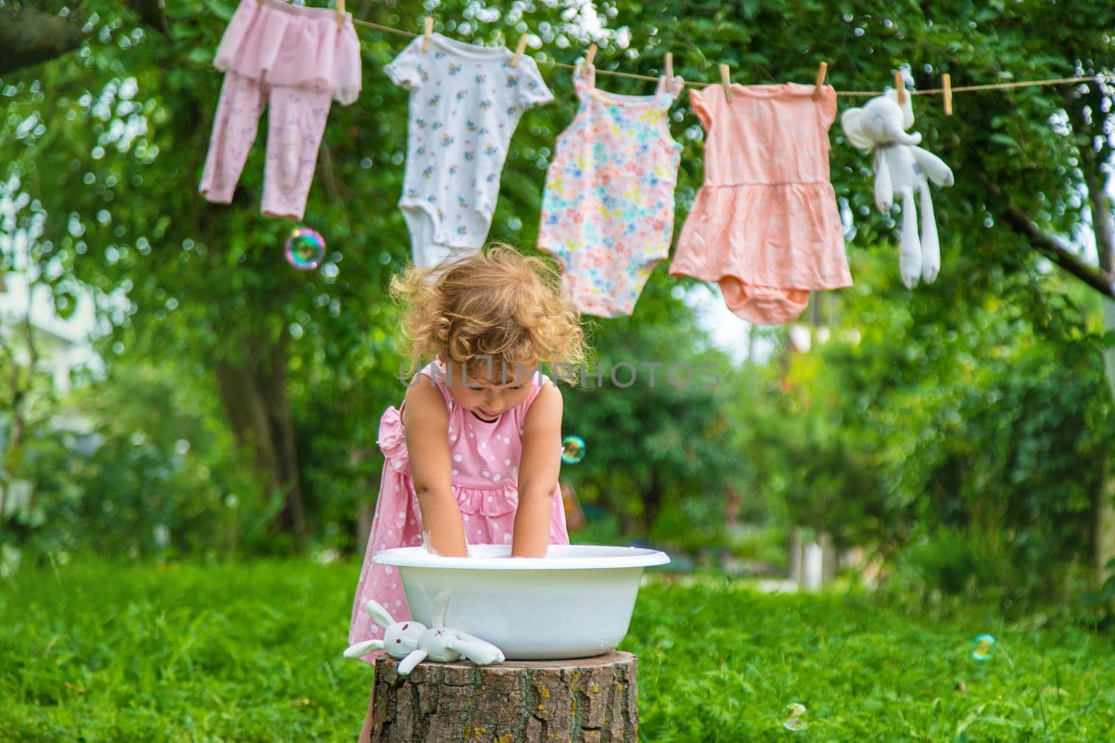 The child washes clothes and toys. Selective focus. Kid.