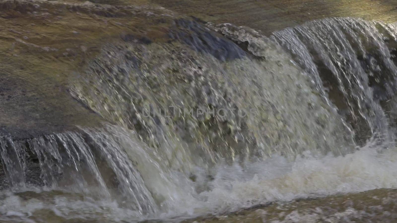 Slow motion video showing clear water flowing over rocks.