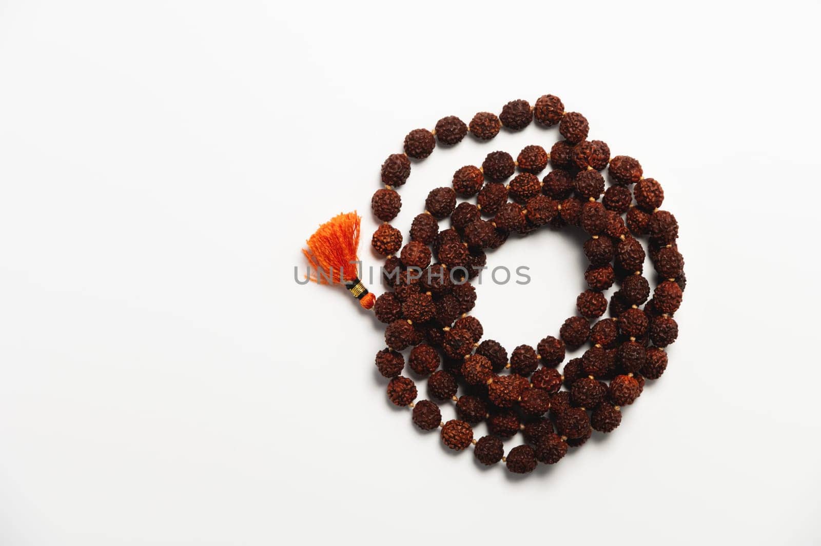 Wooden church rosary made of dark wood on a white background. Church rosary for prayer close-up.