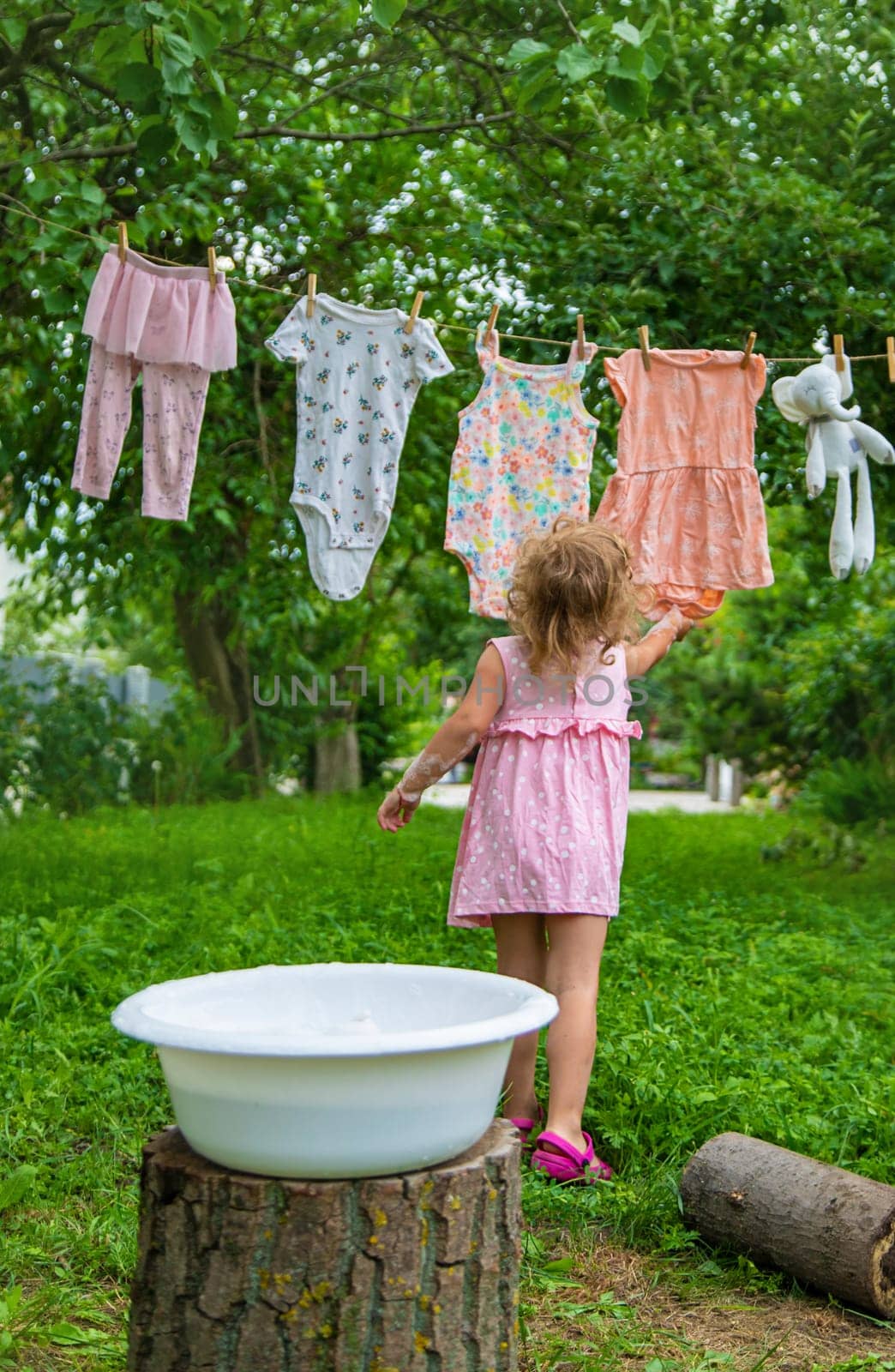 The child washes clothes and toys. Selective focus. Kid.