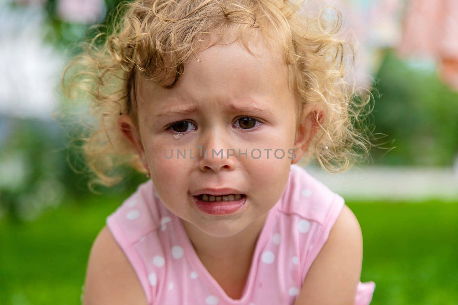 Child girl crying in the park. Selective focus. Kid.