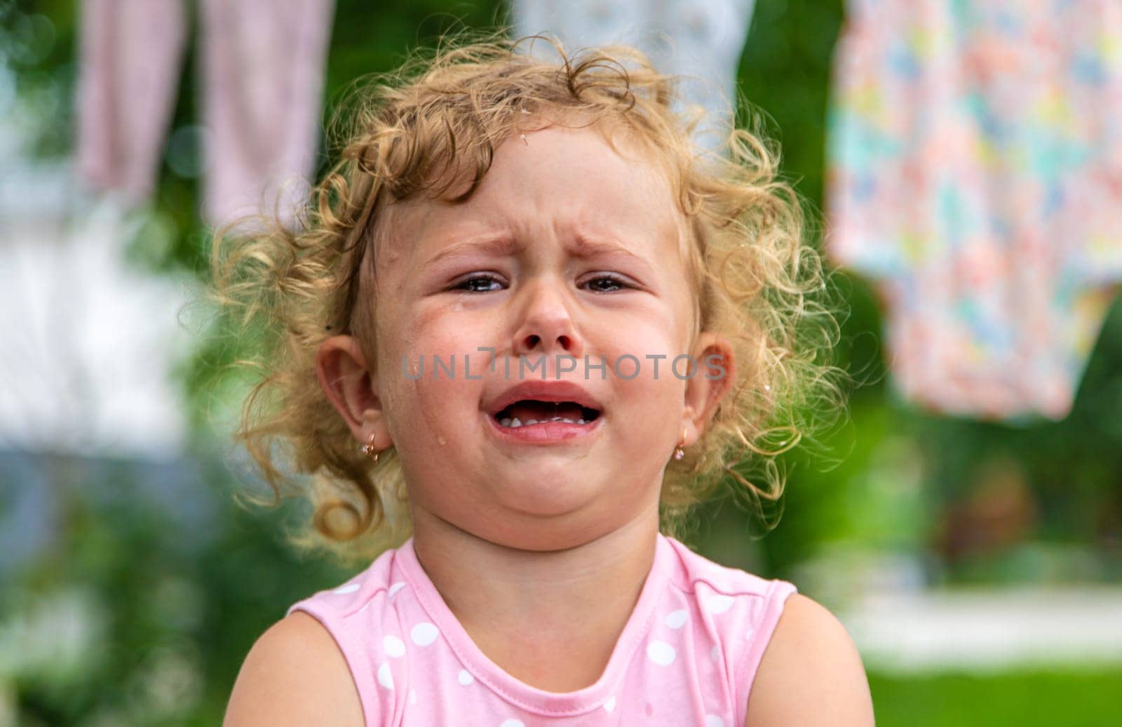 Child girl crying in the park. Selective focus. Kid.