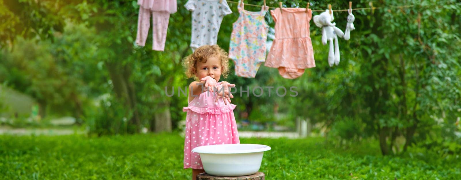 The child washes clothes and toys. Selective focus. Kid.