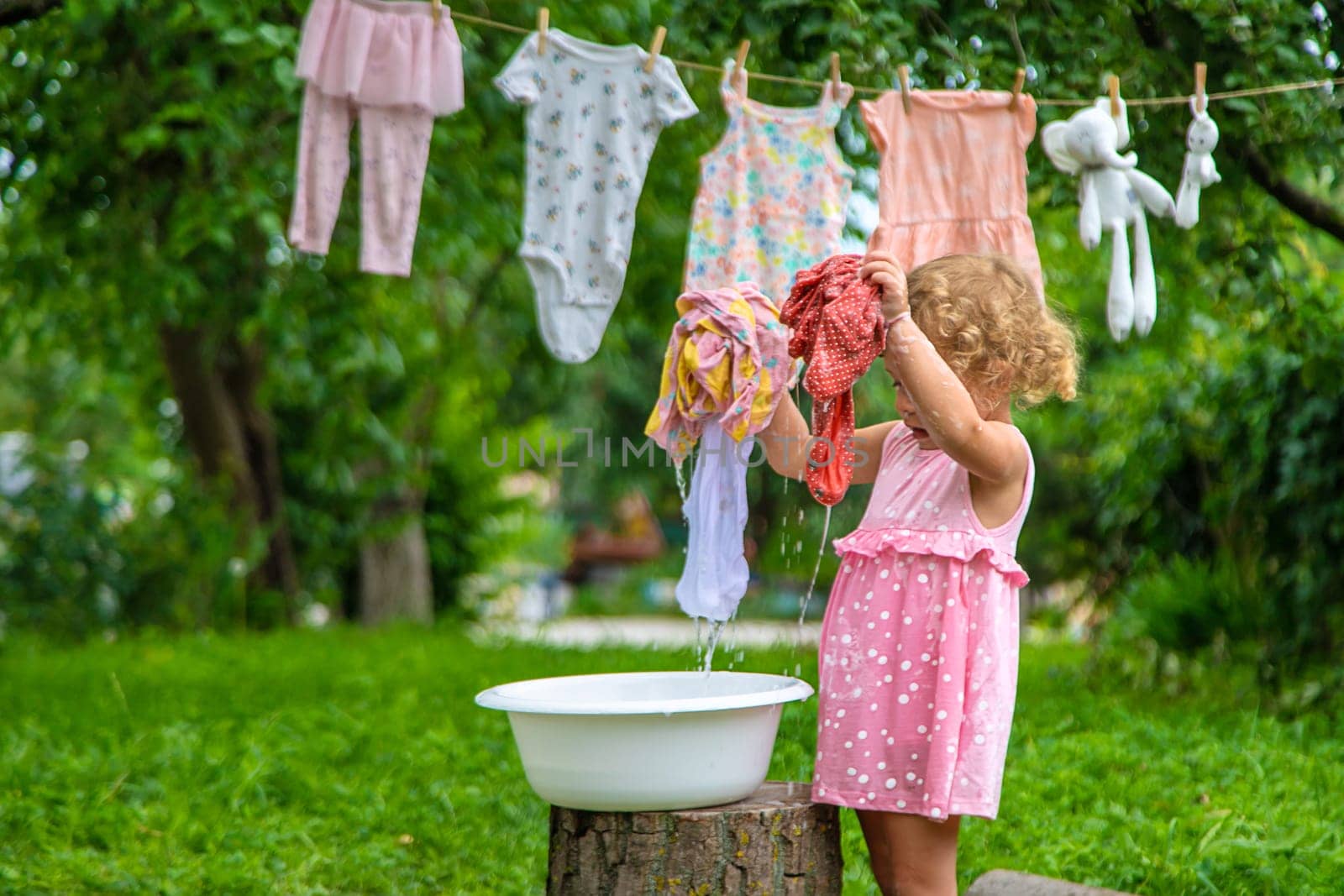 The child washes clothes and toys. Selective focus. Kid.