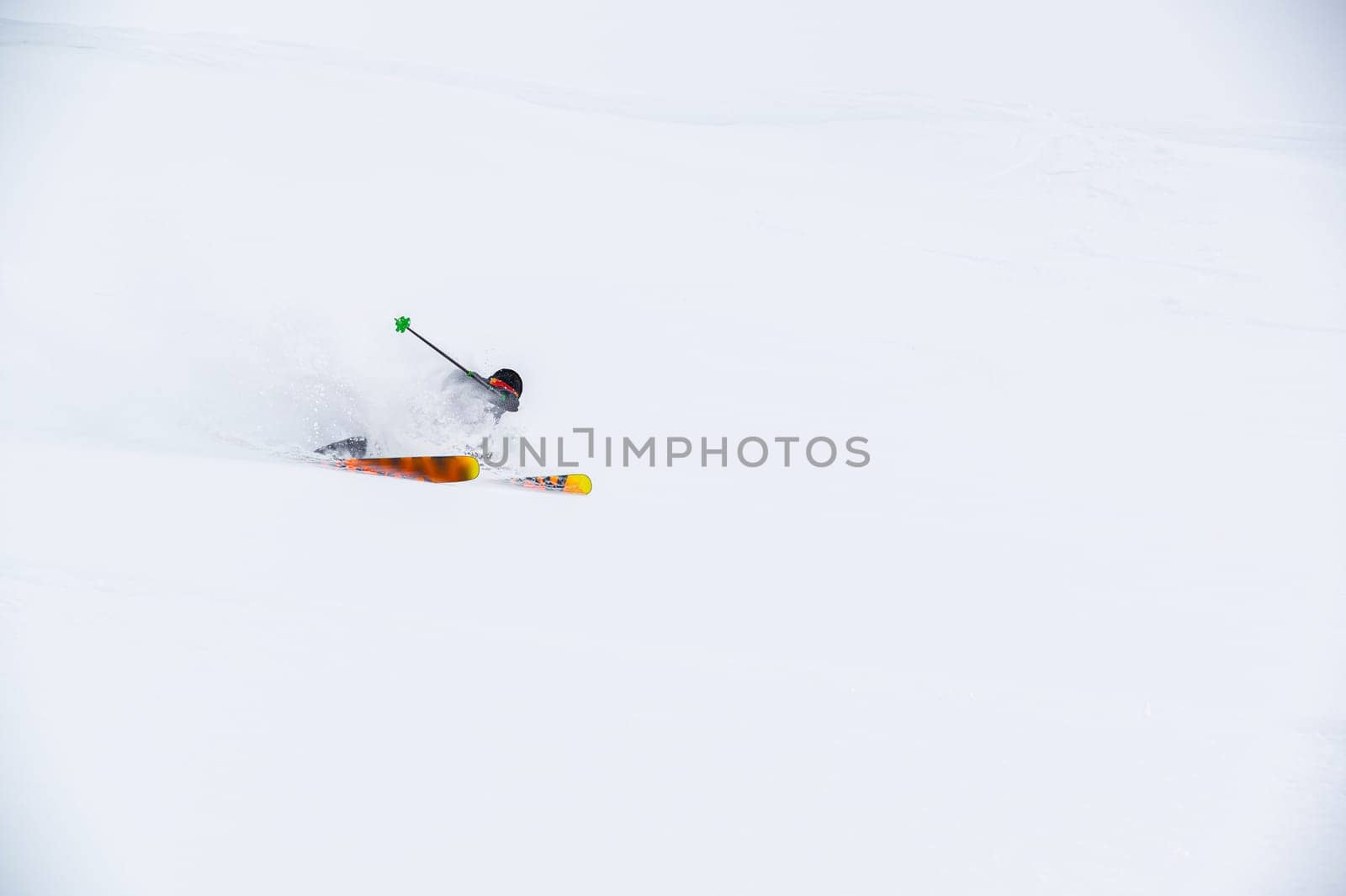 A skier on the piste, going down the slope among the Alpine mountains, which are not visible due to cloudiness.