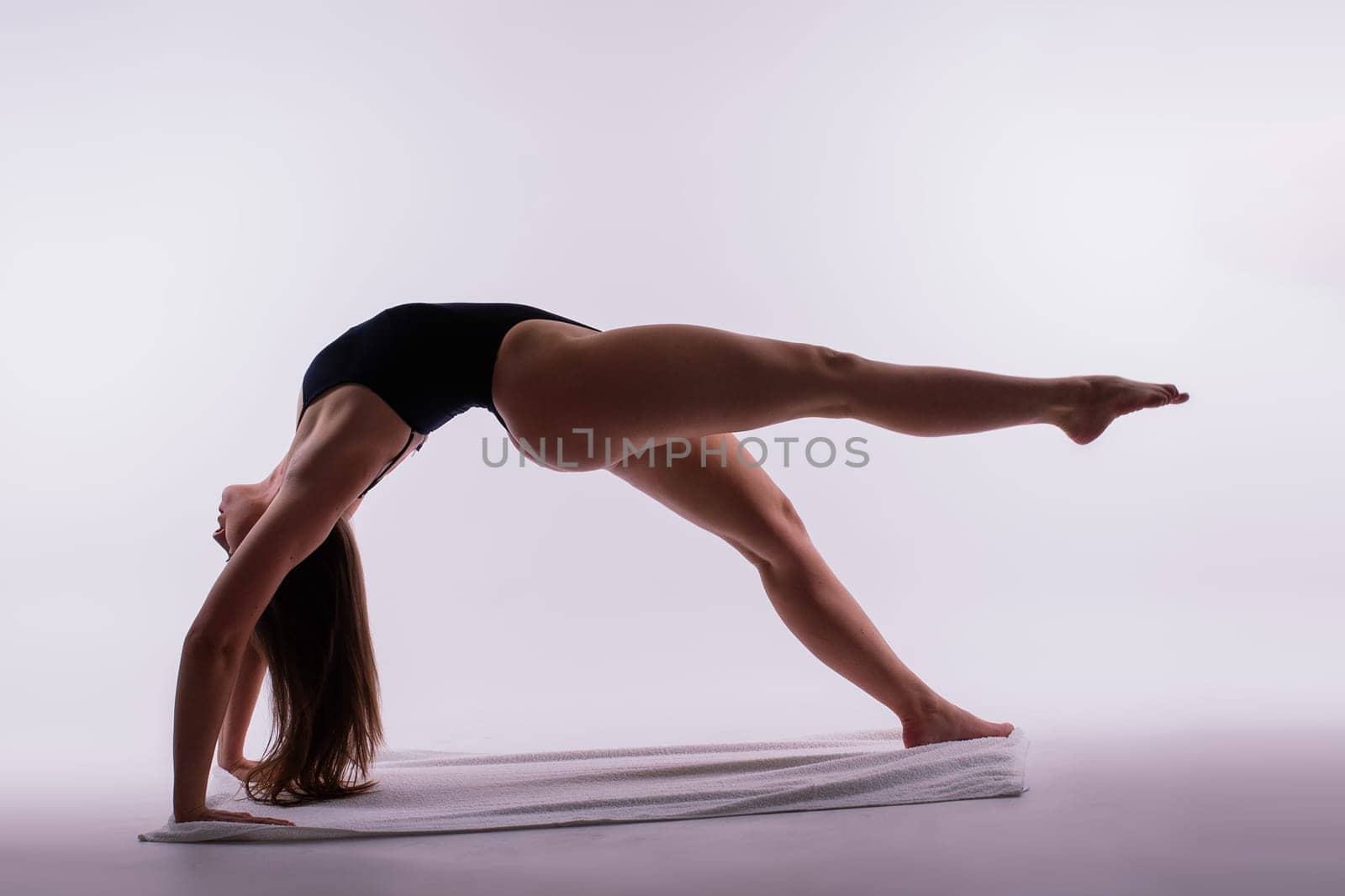 Young beautiful yoga female posing on a studio background by Zelenin