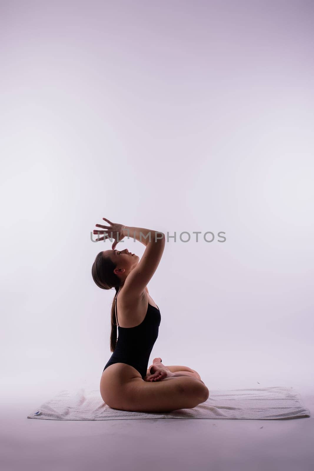 Young beautiful yoga female posing on a studio background by Zelenin