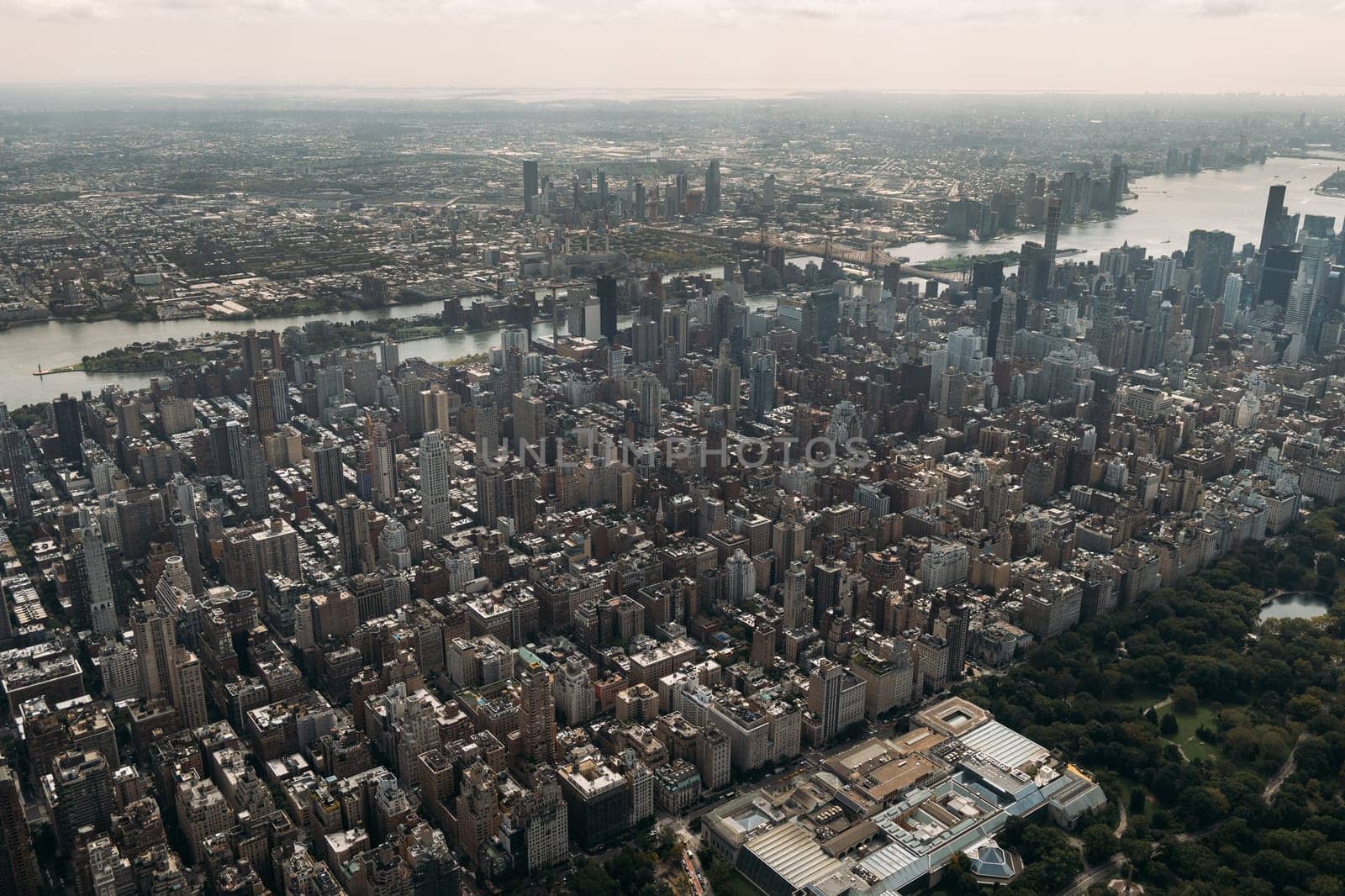 Stunning aerial view of New York City featuring the dense urban landscape, iconic skyline, and lush Central Park. Captured on a sunny day, showcasing the vibrant and bustling nature of the city.