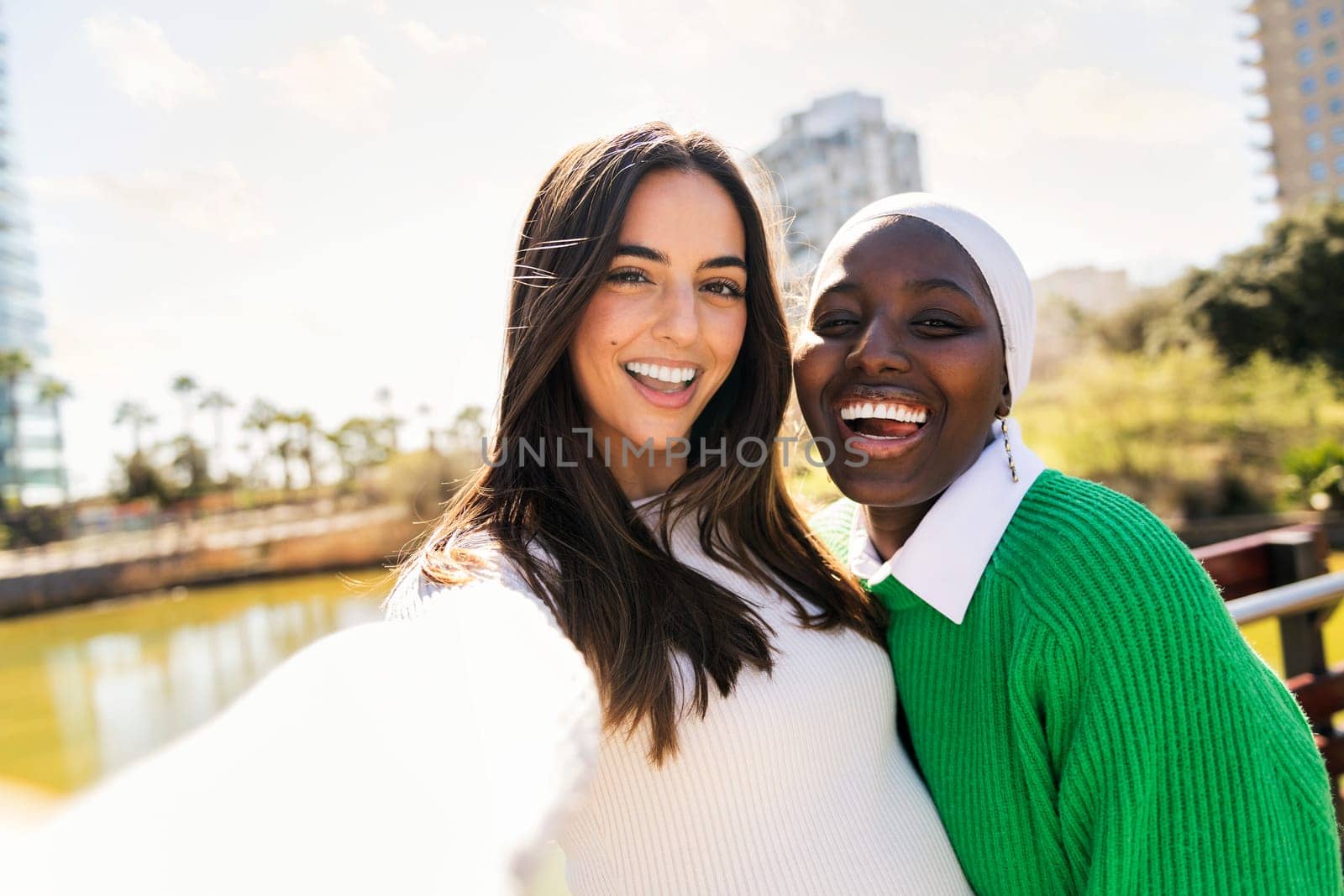 selfie photo of two young women friends smiling happy and carefree in a city park, concept of diversity and modern lifestyle, copy space for text