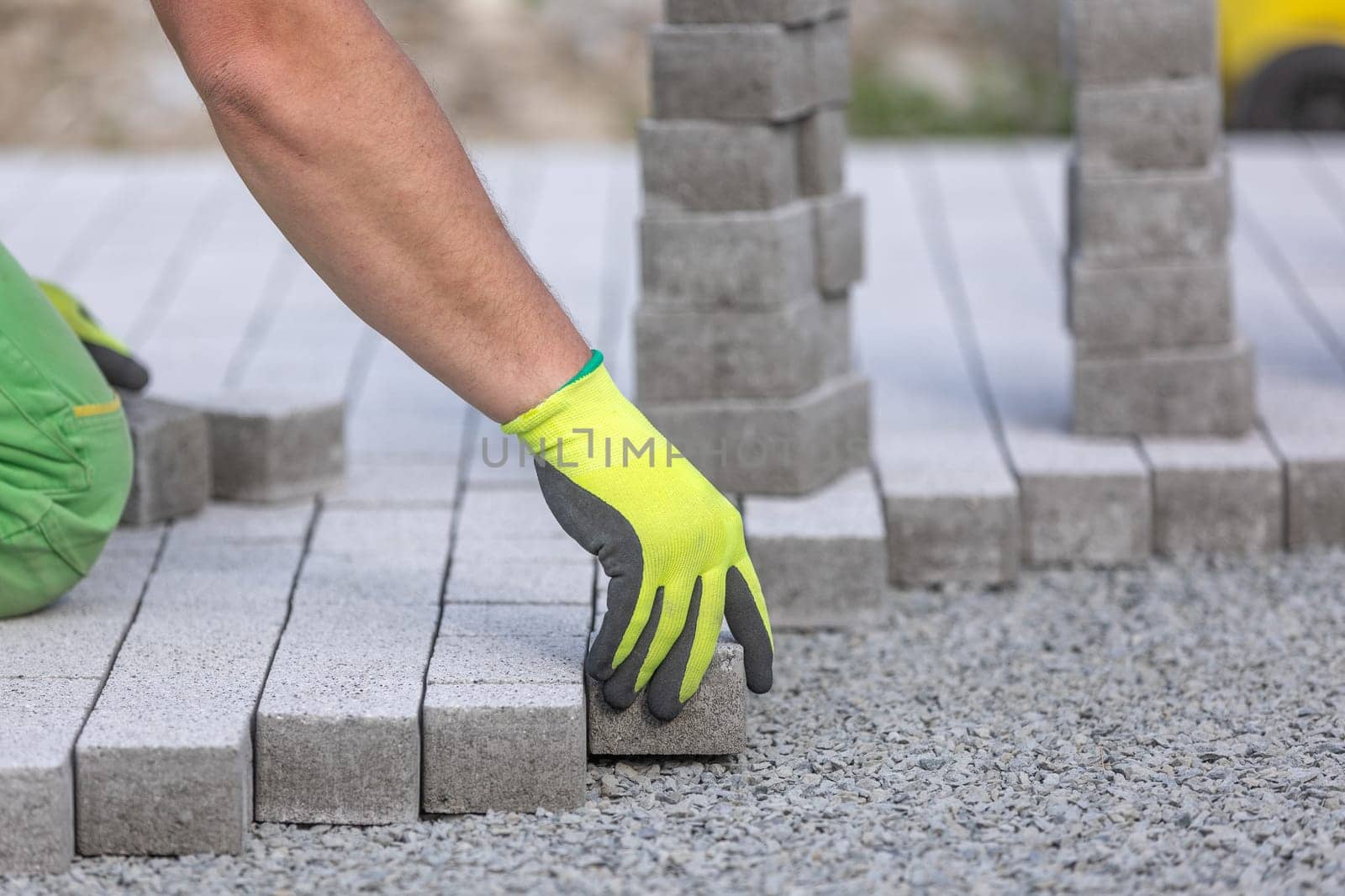 Process of building sidewalk, a aworker laying interlocking walking path, industrial concept