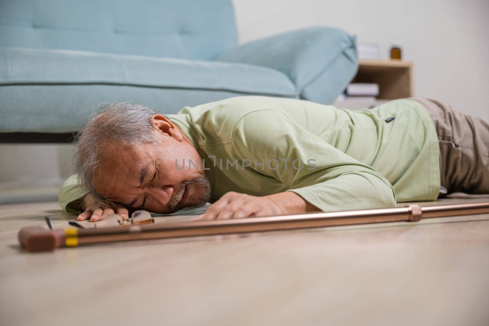Sick senior old man falling down lying on the ground because stumbled at home by Sorapop