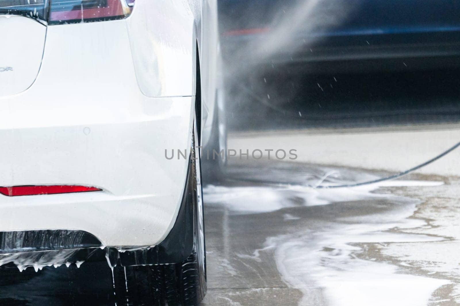 Efficiently cleaning an electric car in the comfort of a suburban driveway, combining eco-consciousness with practicality.