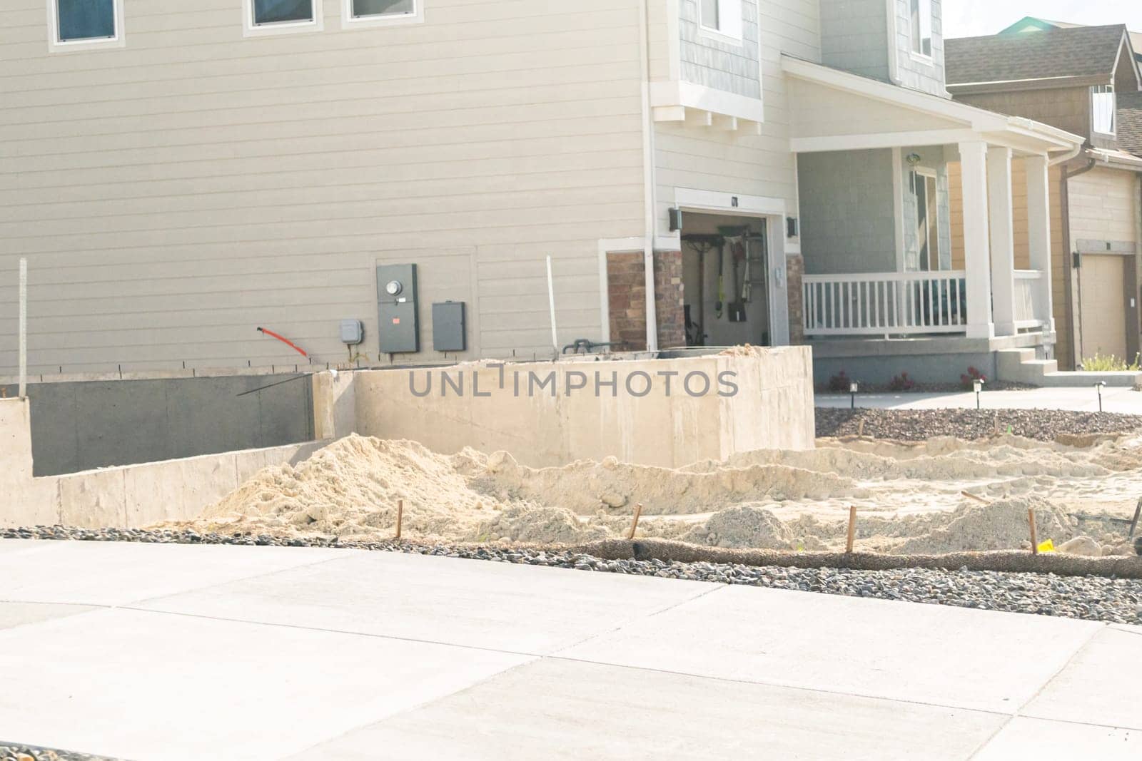 An ongoing construction site in the suburbs, featuring the foundation stage of a single-family house.