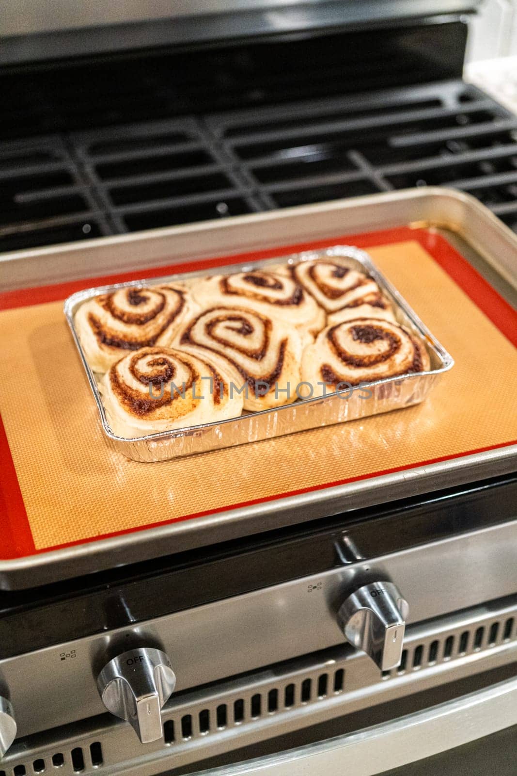 Freshly Baked Cinnamon Rolls Cooling on Stove Top by arinahabich
