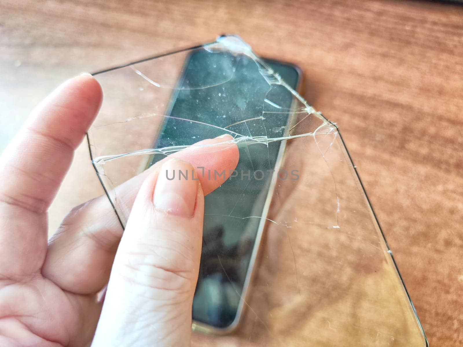 Removing Protective Film From Cracked Screen. Peeling off a cracked screen protector from a phone