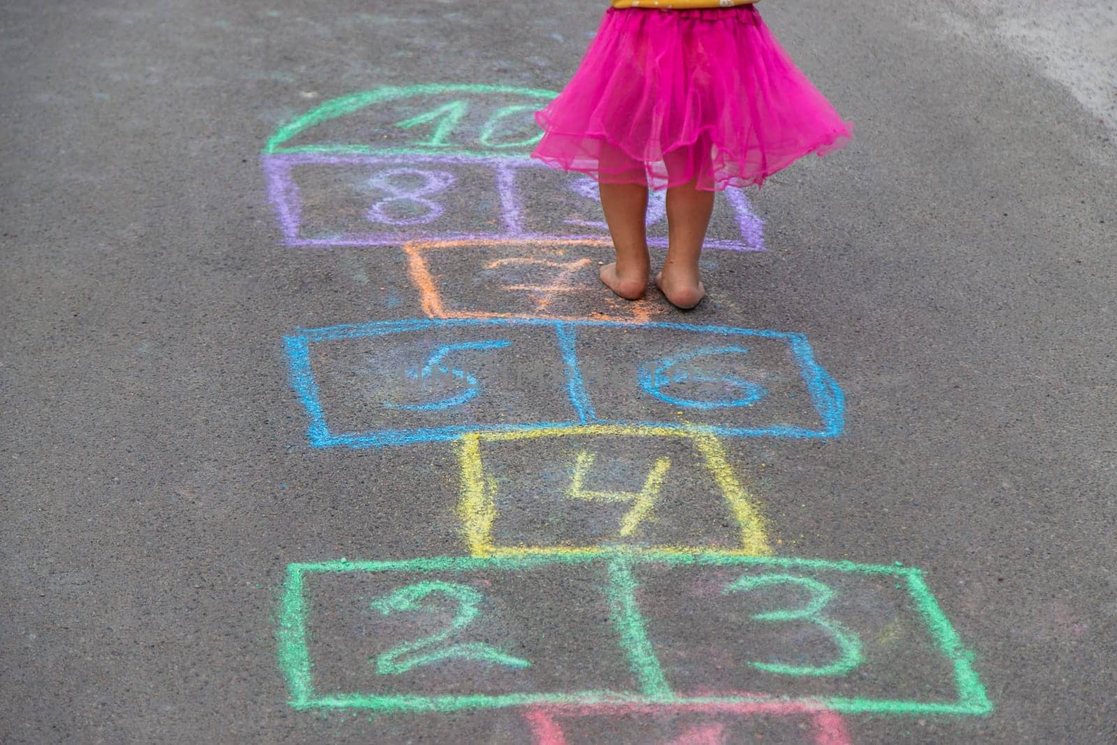 Children play hopscotch on the street. Selective focus. Nature.