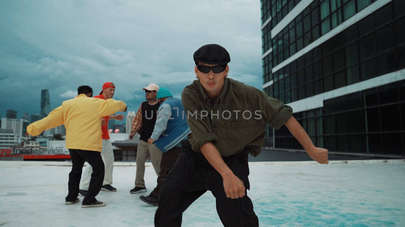 Professional asian dancer practice B boy dance while multicultural friends dancing at roof top. Young modern dancing group doing hip hop movement. Style,fashion,action. Outdoor sport 2024. Endeavor.