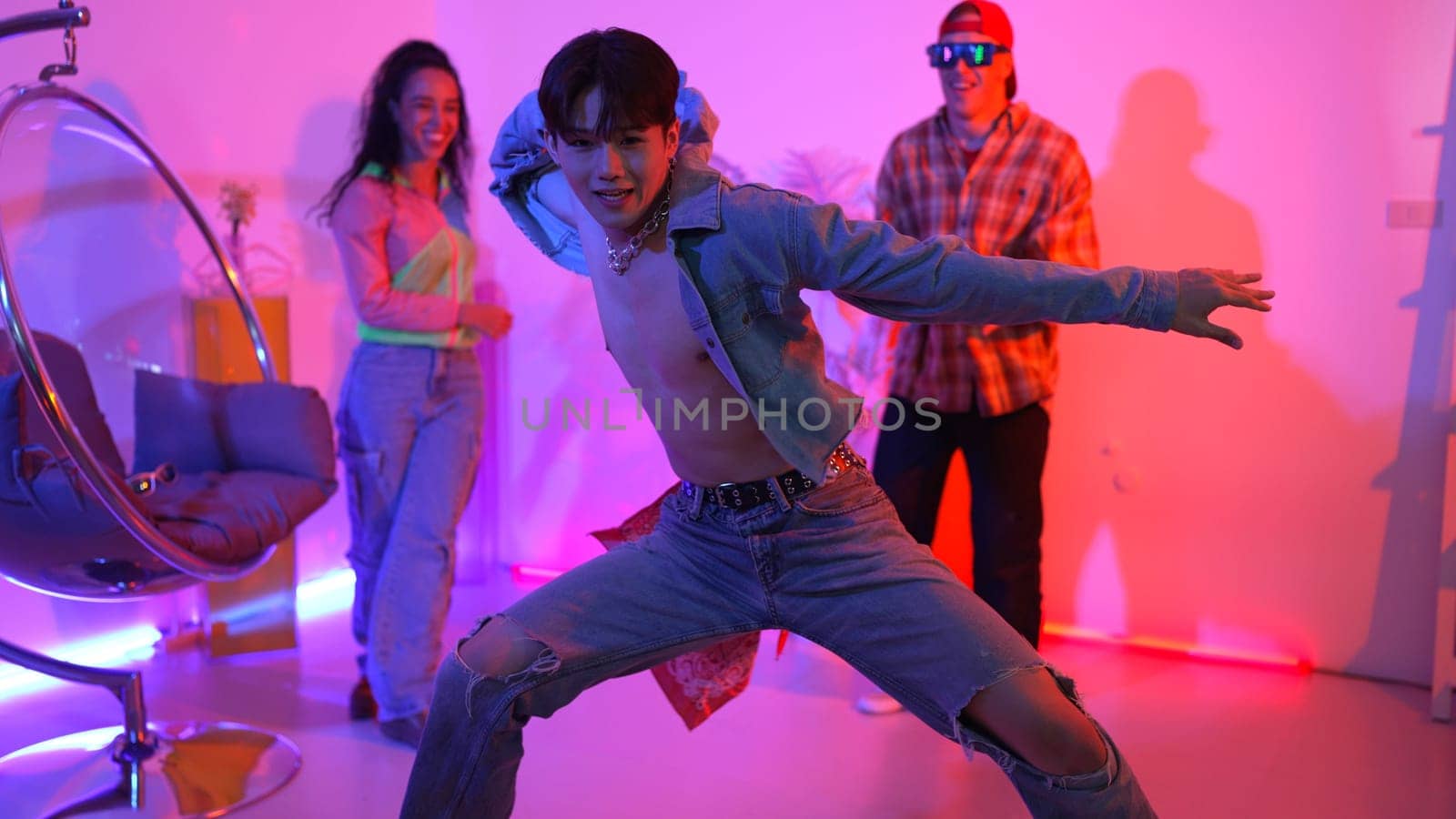 Attractive asian dancer with casual cloth dancing and looking at friend cheering him. Caucasian man and hispanic hipster perform street dancing while turn around and looking at happy team. Regalement.