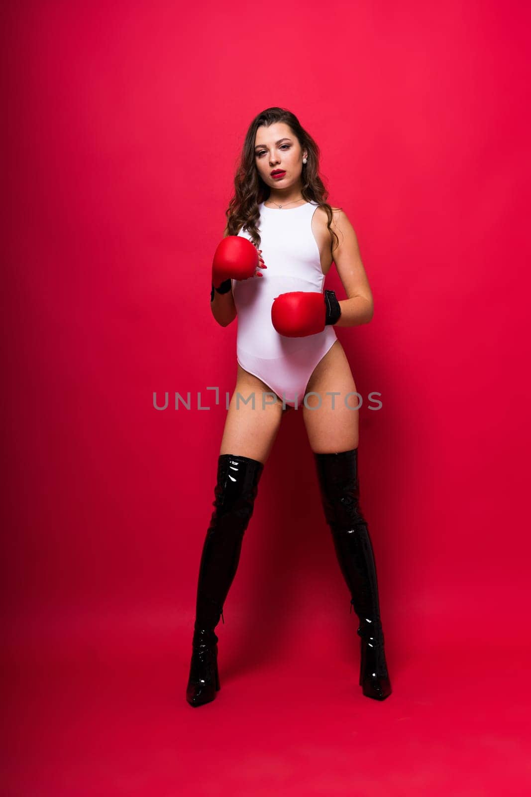 Attractive young brunette woman in boxers gloves, studio shot by Zelenin