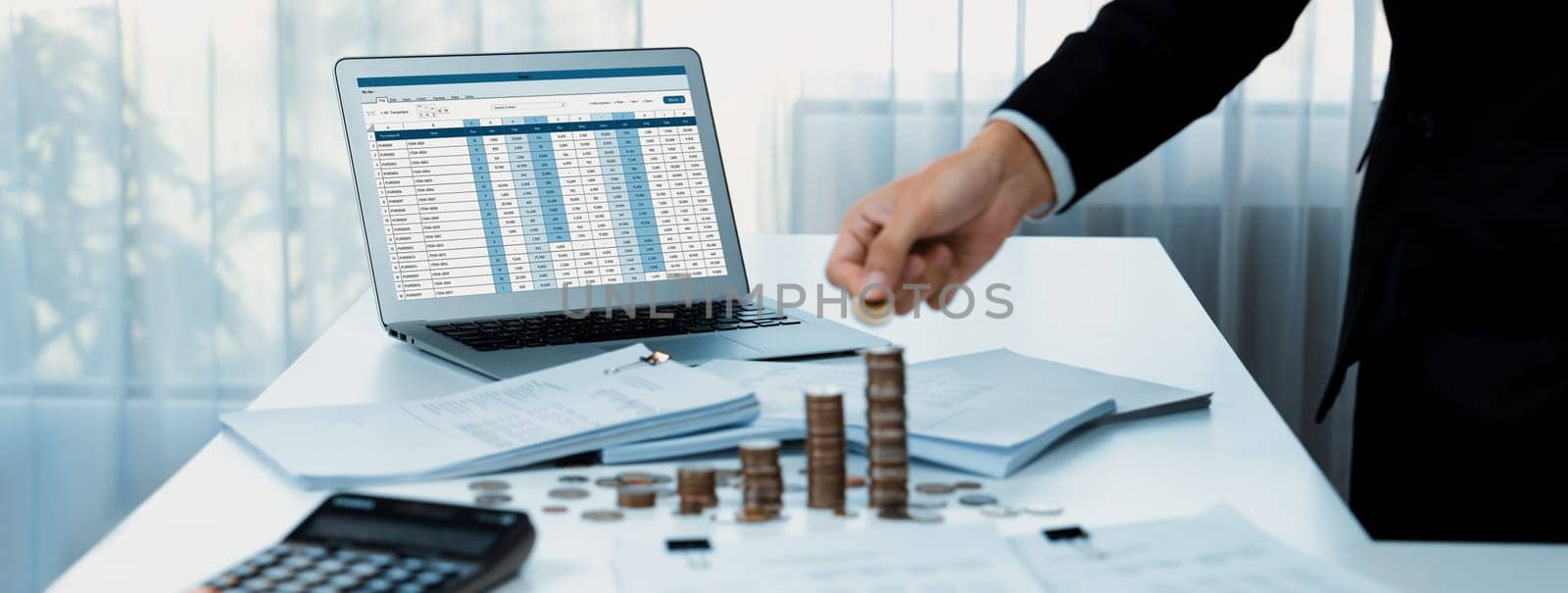 Corporate accountant use accounting software on laptop to calculate and maximize tax refunds and improve financial performance with business investment concept of growth stack coin in panorama. Shrewd