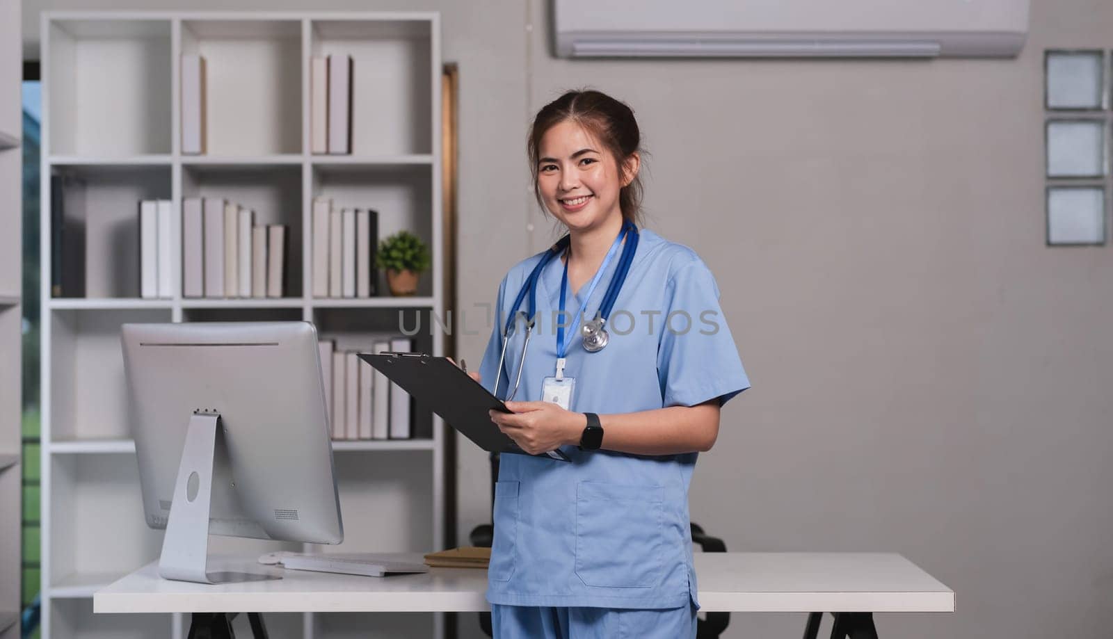 Asian nurse smiling in a modern medical office. Concept of healthcare, professionalism, and care.