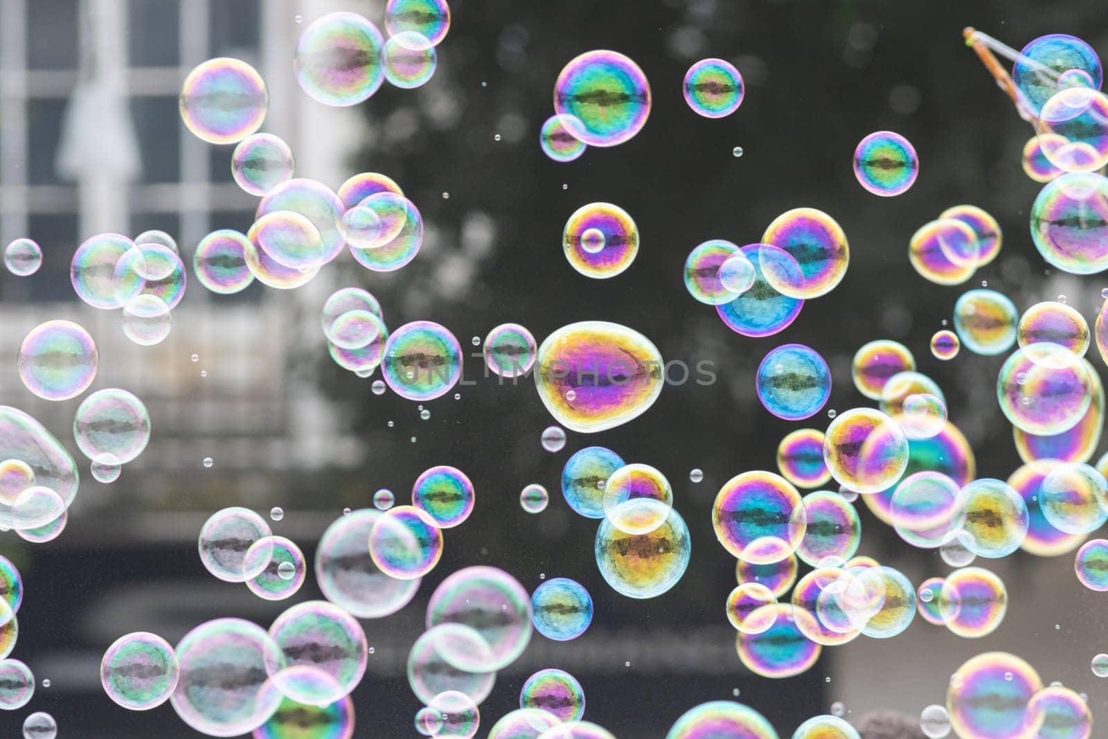 Lots of colorful soap bubbles on the street. Mid shot