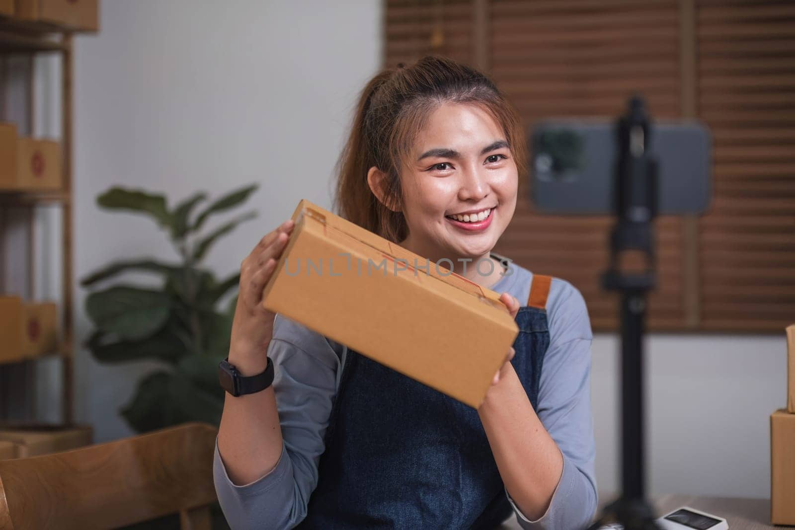 Asian blogger review products and video camera on her phone, sell them online, and showcase her products online on social media. ecommerce business live streaming vlog new normal concept.