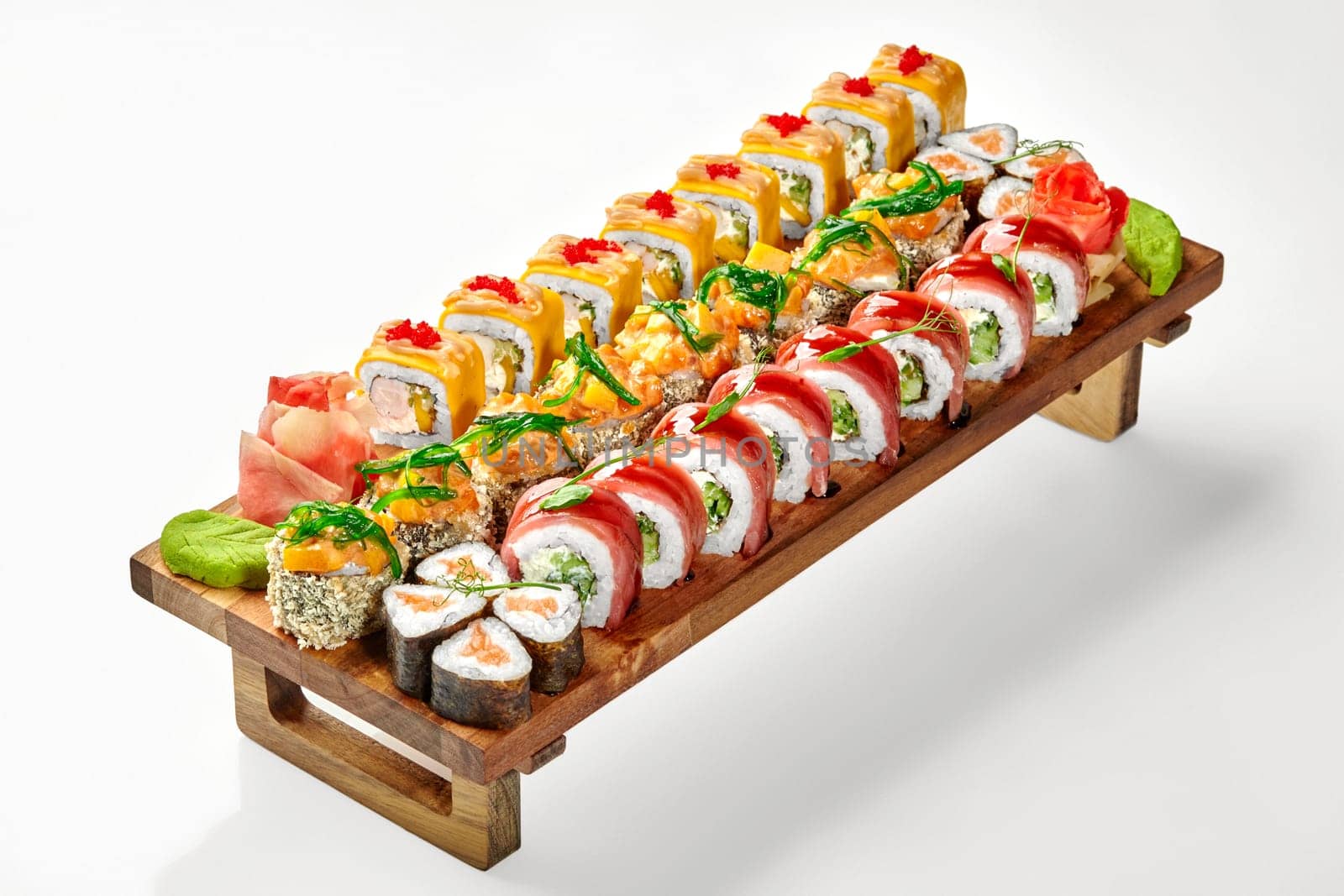 Delicious set of assorted sushi rolls on wooden tray by nazarovsergey