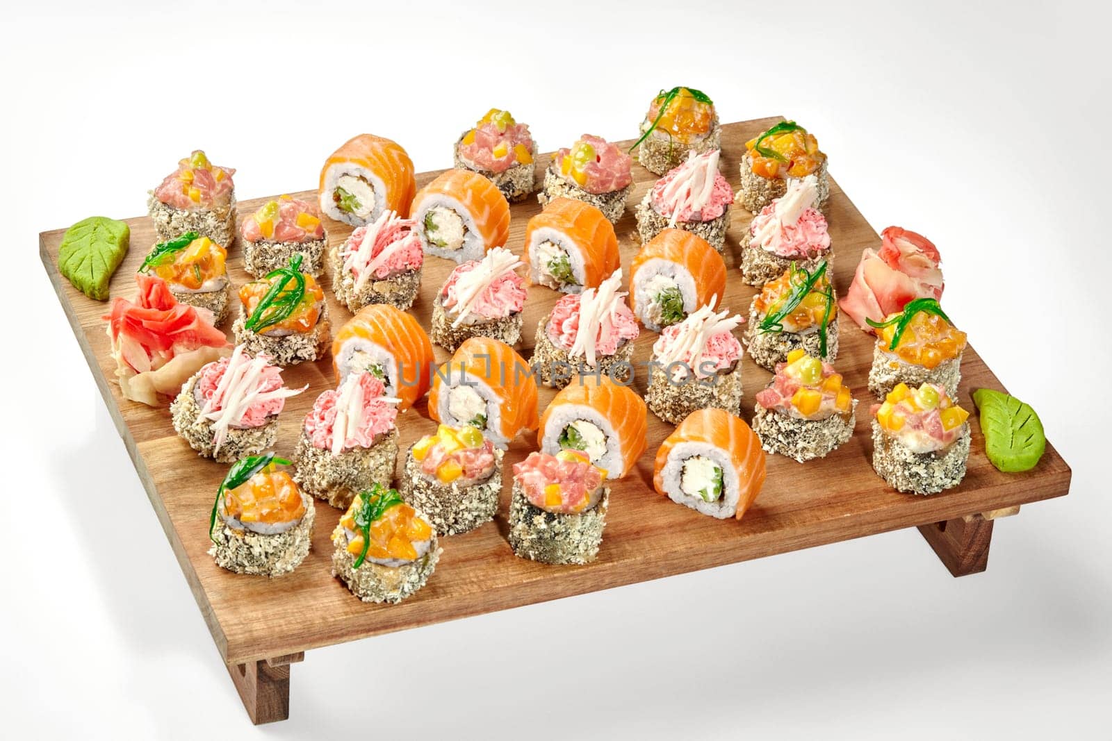 Delicious set of sushi rolls with various toppings on wooden tray by nazarovsergey