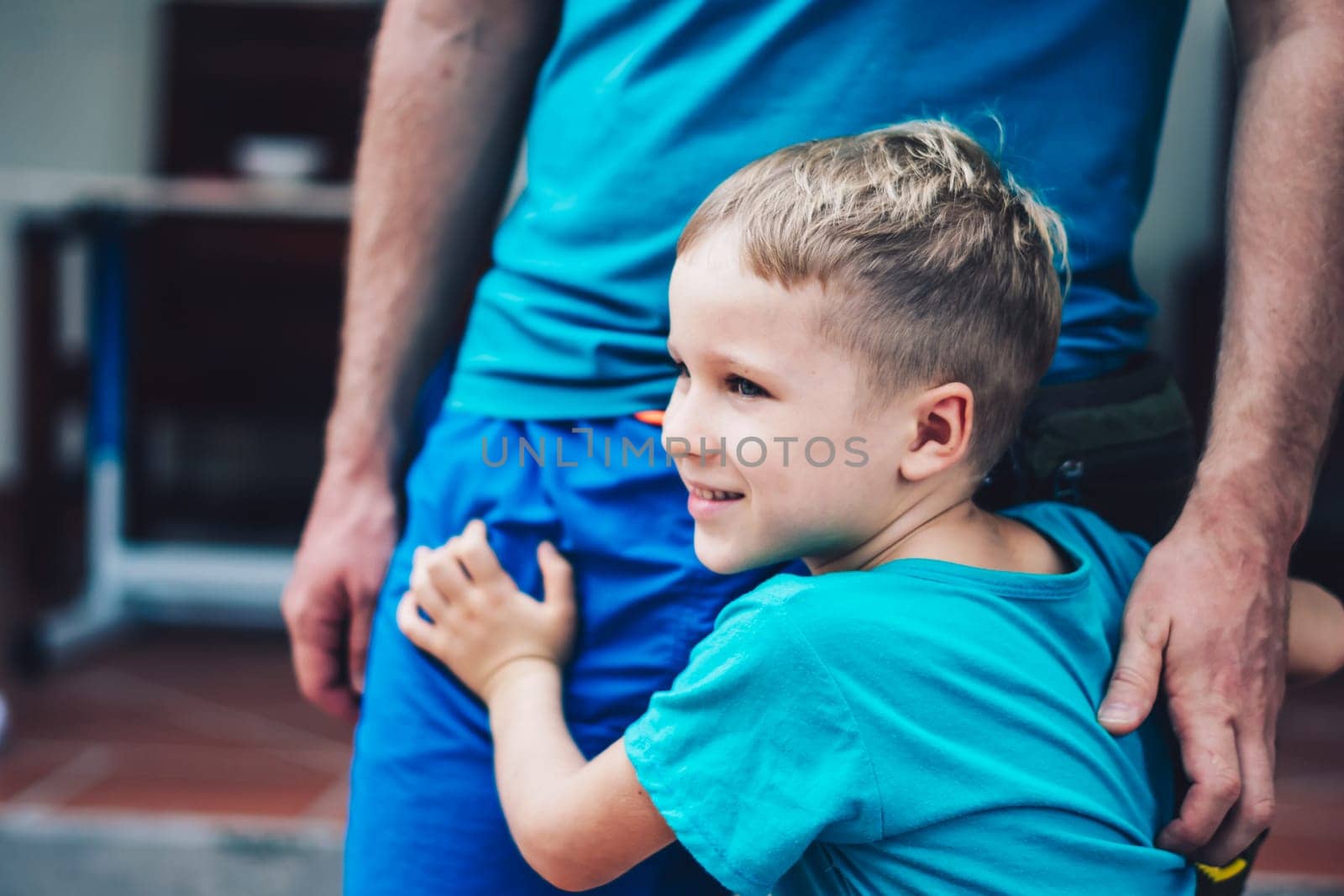 Closeup image of little son tender hugging his fathers hands. Happy childhood parenthood harmony.