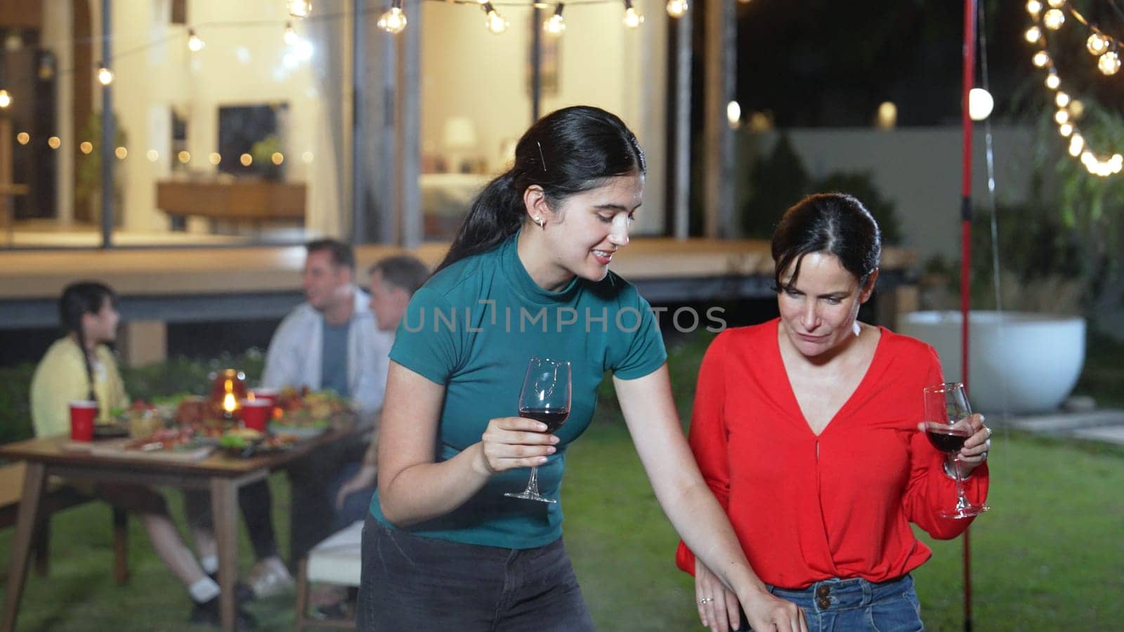 Family gather celebrate holiday. Focus Mother and grandmother drink wine and grill food for family member in dinner party. Outdoor activity spend time with relative cross generation gap. Divergence.