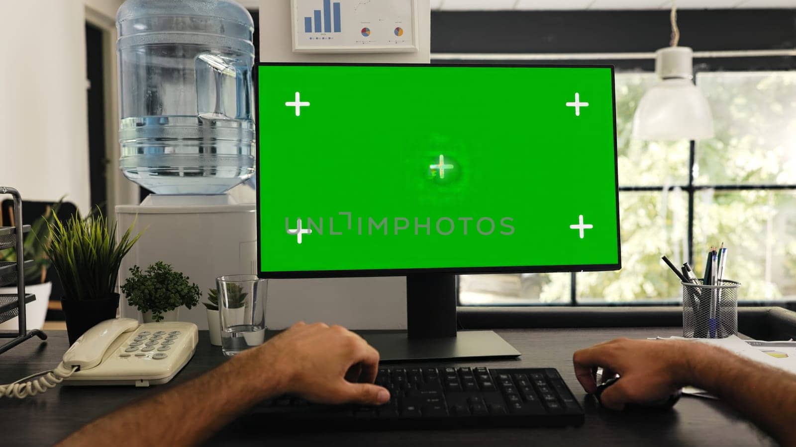 POV of man at desk works with greenscreen and isolated copyspace template, solving business tasks. Company manager sitting at workstation looking at blank chromakey screen. Tripod shot.