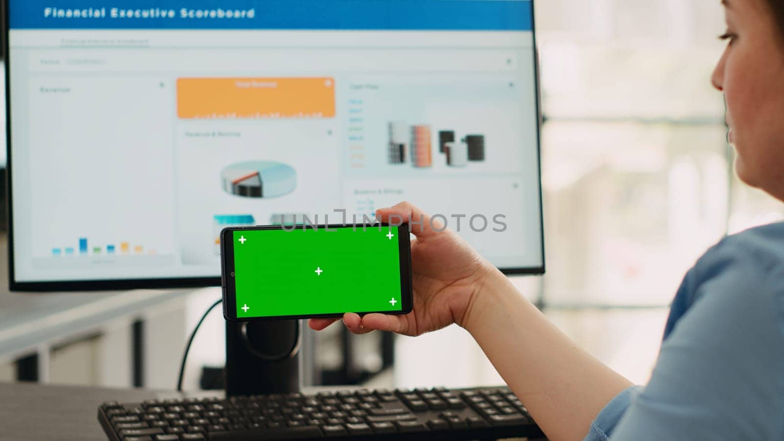 Business operator focusing on blank mockup screen with copyspace overlay while using isolated greenscreen on mobile phone. Employee examining smartphone display with chromakey template.