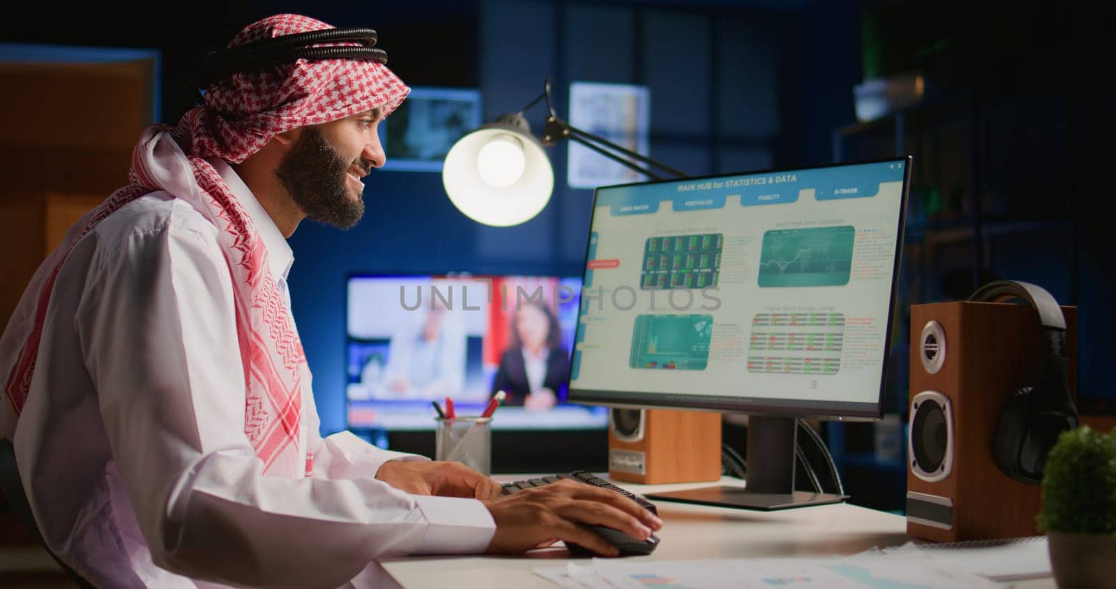 Cheerful muslim broker investor comparing stock exchange valuation financial profit numbers. Arab stockholder in dimly illuminated room looking at market shares growth charts, taking notes