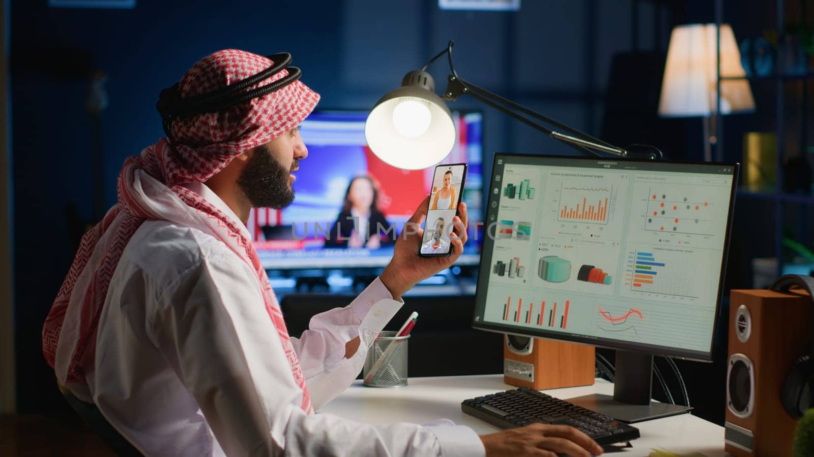 Muslim teleworker and coworkers in call crosschecking analytics statistical data sets in dimly lit apartment office. Arab employee optimizing key performance indicators with colleagues in videocall